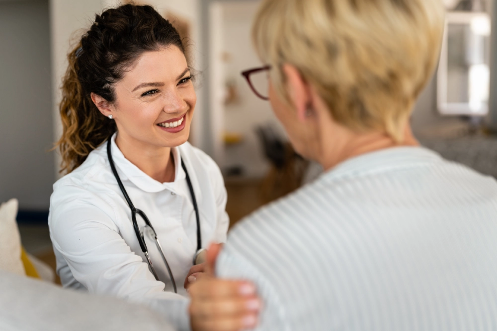 Doctor smiling at patient in white coat.