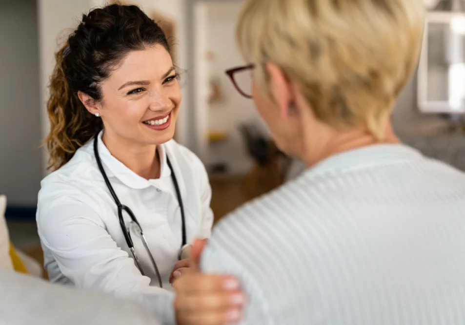 Doctor smiling at patient in white coat.